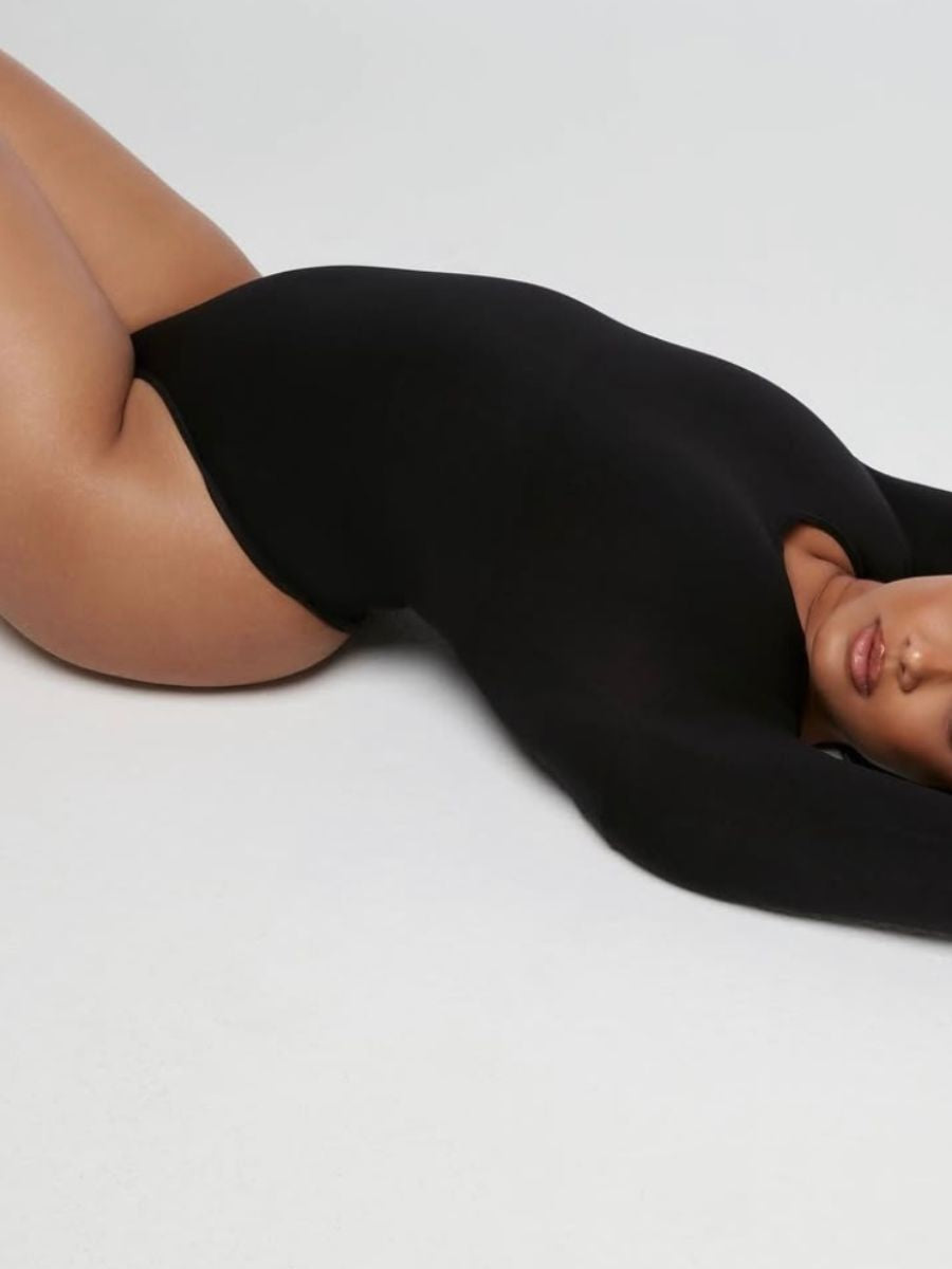 Förmande body i svart med långärmad design och andningsbart material